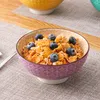A bowl of cereal with blueberries on a table. Náhled obrázku produktu