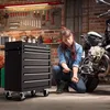 A woman is working on a motorcycle in a garage, with a tool chest nearby. Náhled obrázku produktu