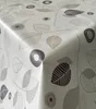 A close-up view of a tablecloth with a leaf pattern, showing the texture and folds of the fabric. Produktbild-Vorschau