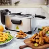 A stainless steel deep fryer is shown on a kitchen counter, surrounded by fried foods like chicken wings and onion rings. Produktbild-Vorschau