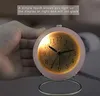 A hand is touching a pink alarm clock with a glowing face. Produktbild-Vorschau