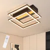 A modern, square-shaped LED ceiling light fixture with multiple interlocking frames, illuminated with white and warm yellow light, mounted on a white ceiling. A white remote control is visible in the lower-left corner. Voir les images du produit