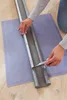 A person is cutting a door draft stopper to size on a cutting mat. Podgląd zdjęcia produktu
