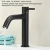 A black faucet with water running into a sink, with folded towels in the background. Produktbild-Vorschau