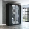 A modern black wardrobe with mirrored sliding doors is shown in a room with a concrete wall and wooden floor. Produktbild-Vorschau