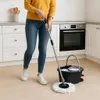 A person is mopping the floor in a kitchen. Podgląd zdjęcia produktu