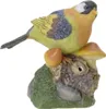 A decorative figurine of a bird perched on a mossy base with mushrooms and an acorn. Produktbild-Vorschau