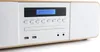 A close-up, angled view of a white and wood-toned micro-stereo system with a blue display screen. Produktbild-Vorschau