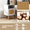 A white wooden nightstand with a rattan door and pine wood legs, shown in a bedroom setting. The image also includes close-ups of the rattan material and wood legs, along with icons representing storage possibilities. Podgląd zdjęcia produktu