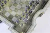 A close-up view of a Lord of the Rings themed chess set, with intricate metallic pieces arranged on the board. Podgląd zdjęcia produktu