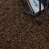 A close-up view of a brown shaggy carpet with a black magazine rack in the upper right corner. Anteprima dell’immagine prodotto