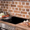 A kitchen counter with a stovetop, a frying pan, and ingredients for cooking. Anteprima dell’immagine prodotto