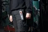 A person wearing work pants with a tool attached to their belt. Podgląd zdjęcia produktu