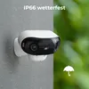 A security camera mounted on a wall during a rain shower, with text indicating its weather resistance. Produktbild-Vorschau