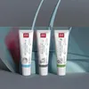 Three tubes of SPLAT toothpaste are arranged in a row against a modern, abstract background. Produktbild-Vorschau