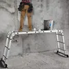 A person wearing a tool belt stands on a multi-purpose ladder with a bucket of paint. Produktbild-Vorschau