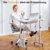 A woman is sitting at a height-adjustable desk with a laptop and a cup of coffee, with her feet resting on a footrest. Podgląd zdjęcia produktu