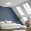 A bedroom with a bed, a plant, and a record player. Produktbild-Vorschau