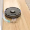 A robot vacuum cleaner is shown cleaning a wooden floor, with an illustration of airflow and dirt being picked up. Produktbild-Vorschau