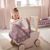 A young girl playing with a doll stroller in a room. Náhled obrázku produktu