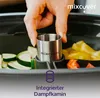 A hand is placing a metal insert into a cooking pot filled with vegetables. Produktbild-Vorschau