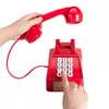 A hand is holding a red telephone handset while another hand presses a button on the base of the phone. Podgląd zdjęcia produktu