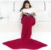 A woman is sitting on a bed, reading a magazine while wrapped in a mermaid tail blanket. Anteprima dell’immagine prodotto
