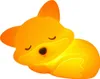 A glowing orange fox-shaped night light lying on its side. Produktbild-Vorschau