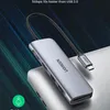 A close-up of a silver USB-C hub with multiple ports, connected to a laptop. Produktbild-Vorschau