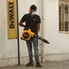 A man wearing safety gear is holding a DeWALT leaf blower. Podgląd zdjęcia produktu