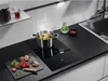 A modern kitchen counter with a black induction hob, a pot of food cooking, and ingredients laid out. Anteprima dell’immagine prodotto