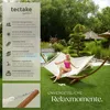 A woman relaxing in a hammock in a garden setting. Produktbild-Vorschau