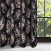 A curtain with a palm leaf pattern hanging in front of a window. Produktbild-Vorschau