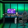 A gaming desk setup in a room with a city view at night, illuminated by green LED lights. Voir les images du produit