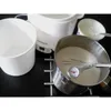 A yogurt maker with accessories and a pot of milk on a black surface. Anteprima dell’immagine prodotto