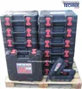 A stack of black tool cases with red accents, a single tool case in the foreground with branding, and a nail gun next to it, all on a wooden pallet. Produktbild-Vorschau