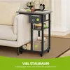 A side table next to a sofa, with items on and around it. Produktbild-Vorschau