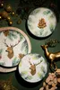 A festive Christmas-themed arrangement featuring plates, decorative deer, and pine branches. Podgląd zdjęcia produktu