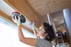 A woman is sanding a wooden beam near a window. Anteprima dell’immagine prodotto