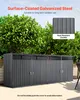 A dark gray outdoor storage shed for trash cans, set against a backdrop of green bushes and a light sky. Podgląd zdjęcia produktu