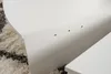 A close-up view of a white table with pre-drilled holes on its side, resting on a fluffy rug. Produktbild-Vorschau