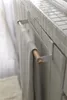 A towel hanging on a white towel rack mounted on a tiled wall. Náhľad obrázku produktu