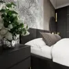 A bedroom scene with a bed, nightstand, and wallpaper. Produktbild-Vorschau