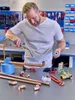 A man is soldering copper pipes on a workbench. Produktbild-Vorschau