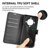 A hand holding an open black flip phone case, revealing the interior card slots and the phone holder section with a circular camera cutout. Produktbild-Vorschau