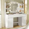 A white vanity table with a mirror and lights, stocked with makeup and accessories, set against a neutral background with curtains. Náhled obrázku produktu