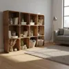 A living room scene with a wooden crate shelf unit filled with decorative items, a sofa, and a floor lamp. Náhled obrázku produktu
