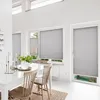 A dining room with white walls and furniture, featuring pleated blinds on the windows. Produktbild-Vorschau