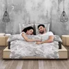 A couple sleeping in a bed with floral patterned bedding. Produktbild-Vorschau