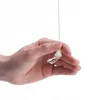 A hand is holding a white pull cord with a white plastic end piece. Anteprima dell’immagine prodotto